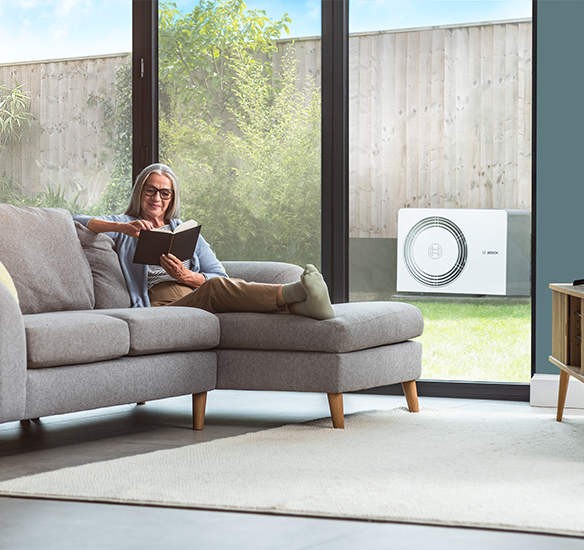 woman on sofa with heat pump outside