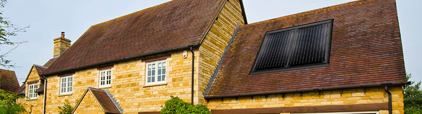 Photo of a country house with a solar panel on the roof