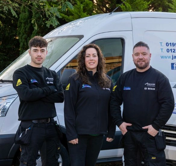Jay with his family standing in front of a van