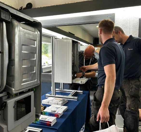 installers at roadshow in front of open boiler