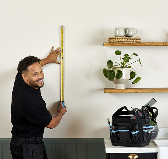 Installer measuring wall